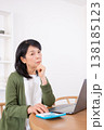 パソコンと電卓を使いながら悩む50代女性 138185123