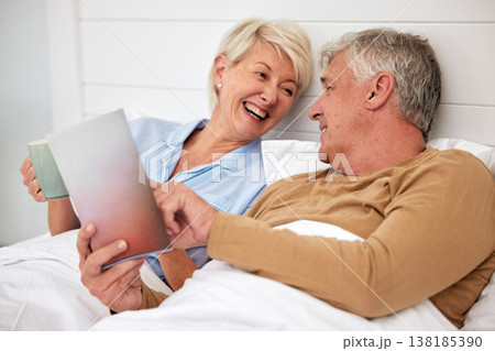 Bed, book and senior couple with love, conversation and marriage with creativity, relax and retirement. Novel, storytelling and old woman with elderly man, bedroom and home with discussion or resting 138185390