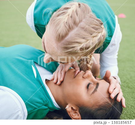 First aid, breathing and emergency with a hockey player on a field to save a player on her team after an accident. Fitness, cpr and heart attack with a woman helping her friend on a field of grass First aid, breathing and emergency with a hockey player on a field to save a player on her team after an accident. Fitness, cpr and heart attack with a woman helping her friend on a field of grass 138185657