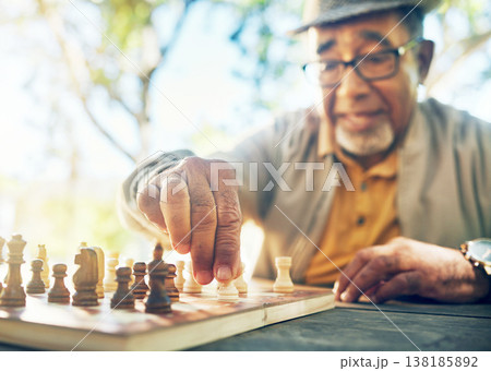 Old man in park, hand with chess game and strategy, competition or challenge, retirement and moving piece. Closeup, planning and contest outdoor, concentration on boardgame and recreation in nature 138185892