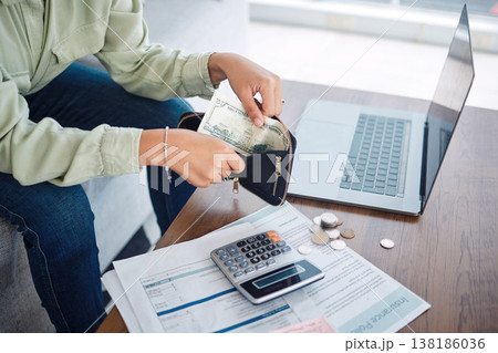 Hands, wallet and cash, budget or bills, money management with laptop and calculator for tax paperwork. Financial plan, person with info on insurance policy documents, audit and loan payment at home 138186036