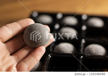 Artisan carefully inspecting sugarcoated chocolate piece during small batch production process Artisan carefully inspecting sugarcoated chocolate piece during small batch production process 138186080