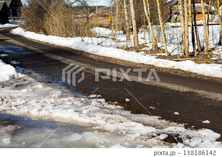 Winter melts away. Peaceful rural scene as snow thaws amidst muddy roadside surroundings Winter melts away. Peaceful rural scene as snow thaws amidst muddy roadside surroundings 138186142