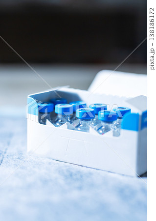 Sterile vials on clean table. Detailed shot of vaccine containers with clinical setting Sterile vials on clean table. Detailed shot of vaccine containers with clinical setting 138186172