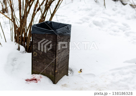 Snowy park with ominous clues. Mysterious scene featuring blood and footprints in winter park Snowy park with ominous clues. Mysterious scene featuring blood and footprints in winter park 138186328