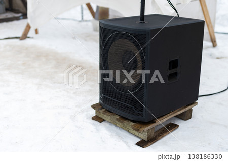 Outdoor audio setup. Industrial sound system positioned outdoors during winter festival Outdoor audio setup. Industrial sound system positioned outdoors during winter festival 138186330