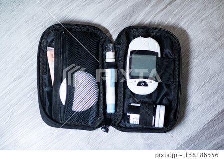 Personal blood sugar measurement kit arranged on gray fabric background for home use 138186356