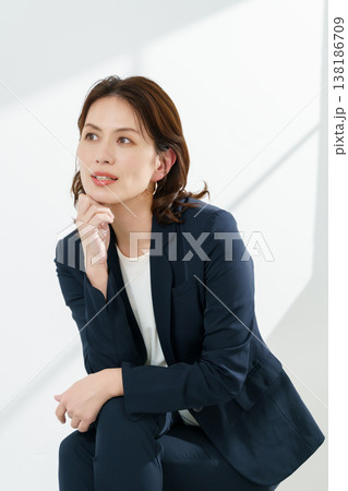白背景の紺のジャケットを着るミドルエイジの女性のポートレート 縦位置 白背景の紺のジャケットを着るミドルエイジの女性のポートレート 縦位置 138186709