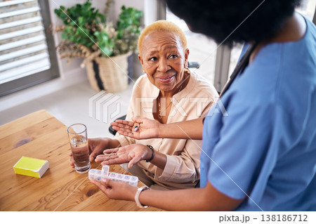 Nurse, smile and giving old woman pills in home with water for healthcare, wellness and support. Caregiver, medicine and African patient with glass to drink medical drugs, supplements and retirement 138186712