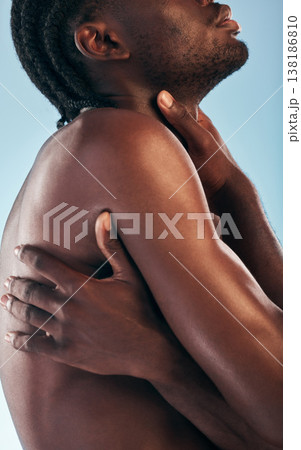 Body, man and muscle in studio with art, skincare and glow from skin wellness and confidence. Hands, hug and male model with creative with blue background and self care with love and strong arms 138186810