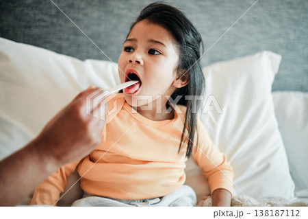 Girl child, check throat and sick in bed with virus, health and wellness, parent monitor daughter at home. Inflammation, illness and young kid with the flu or cold, medical help and support in bed Girl child, check throat and sick in bed with virus, health and wellness, parent monitor daughter at home. Inflammation, illness and young kid with the flu or cold, medical help and support in bed 138187112
