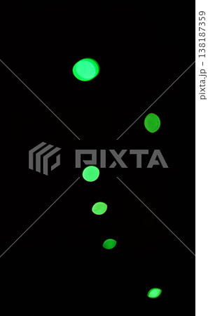 Green light, bokeh and glow on black background isolated on a mockup space. Blur, dark backdrop and defocused shine, sparkle or glitter at night for Christmas, holiday or party with magic color dots Green light, bokeh and glow on black background isolated on a mockup space. Blur, dark backdrop and defocused shine, sparkle or glitter at night for Christmas, holiday or party with magic color dots 138187359