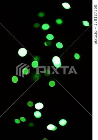 Green light, bokeh and shine on black background isolated on a mockup space. Blur, dark backdrop and defocused glow, sparkle or glitter at night for Christmas, holiday or party with magic color dots 138187368