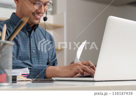 Customer service representative working on a laptop Customer service representative working on a laptop 138187439