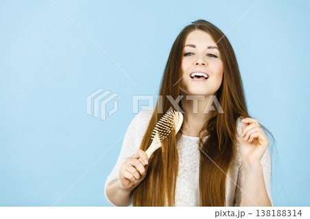 Happy woman brushing her hair Happy woman brushing her hair 138188314