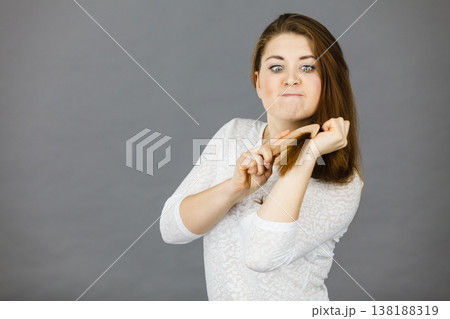 Angry woman trying to brush her hair 138188319