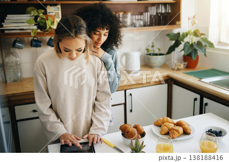 Lesbian, couple and cooking breakfast in kitchen together in morning with nutrition, love and support in home. Lgbt, women or friends with food, juice and preparing healthy diet on counter in house 138188416