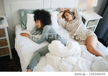 Lgbtq, tired and women sleep on bed in bedroom with fatigue and burnout, dream and relax. Exhausted, people and couple together in house or home lying on pillow in apartment for wellness and calm Lgbtq, tired and women sleep on bed in bedroom with fatigue and burnout, dream and relax. Exhausted, people and couple together in house or home lying on pillow in apartment for wellness and calm 138188420
