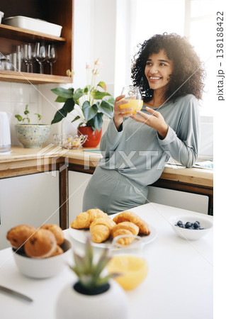 Woman, smile and thinking with orange juice in kitchen for breakfast, nutrition and vitamin c in the morning. Food, person and happiness with idea and drink with pajamas or natural face for wellness Woman, smile and thinking with orange juice in kitchen for breakfast, nutrition and vitamin c in the morning. Food, person and happiness with idea and drink with pajamas or natural face for wellness 138188422