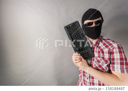 Man wearing balaclava shooting from keyboard Man wearing balaclava shooting from keyboard 138188487