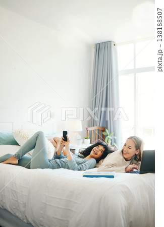 Technology, social media and morning with a lesbian couple in bed together in their home on the weekend. Relax, diversity and an lgbt woman with her girlfriend in the bedroom for love or bonding 138188507
