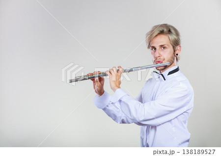 Male flutist playing his flute Male flutist playing his flute 138189527