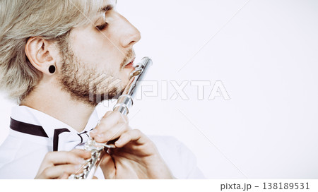 Male flutist playing his flute Male flutist playing his flute 138189531