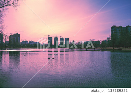Skyline, Kyiv city in the evening. Left bank of the Dnieper River. Lake Telbin at sunset. Beautiful reflection of buildings in the lake 138189821