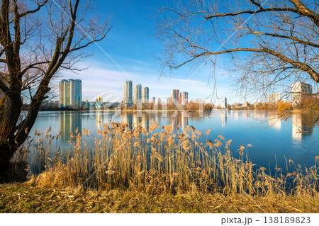 Skyline, Kyiv city in the morning. Left bank of the Dnieper River. Lakeshore with trees in the morning. Beautiful reflection of buildings in the lake 138189823