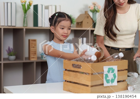 Mother and daughter sorting recyclables together 138190454