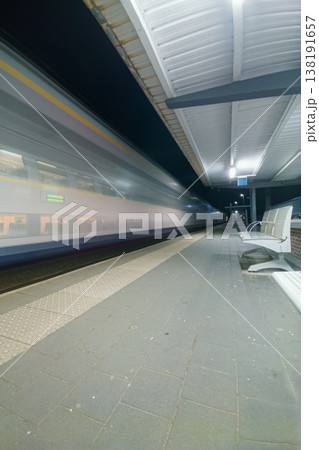 Night Train Passing Empty Platform at Urban Station With Motion Blur, Speed and Solitude Night Train Passing Empty Platform at Urban Station With Motion Blur, Speed and Solitude 138191657