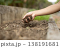 手元から土をこぼして畑の土壌改良を行う農作業のイメージ 138191681