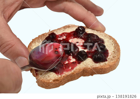 A slice of bread with butter and berry jam 138191826