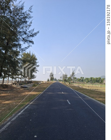 Long Straight Road Passing Through a Scenic Landscape Under Blue Sky 138192178