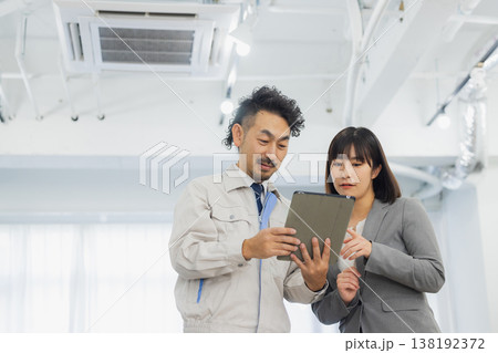 エアコンを見て不満そうな表情のビジネスウーマンと作業員 エアコンを見て不満そうな表情のビジネスウーマンと作業員 138192372