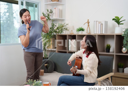 Mother and daughter enjoying music and singing together 138192406