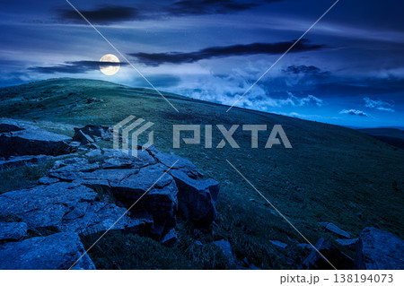 rocks and rolling hills in mountain landscape in summer at night. full moon over scenery with green grass on alpine meadow under dark sky with clouds. mysterious recreation tourism and wanderlust rocks and rolling hills in mountain landscape in summer at night. full moon over scenery with green grass on alpine meadow under dark sky with clouds. mysterious recreation tourism and wanderlust 138194073