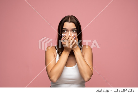 Woman with wide eyes holding back words, conveying a feeling of surprise, mystery, or a sudden realization 138194235