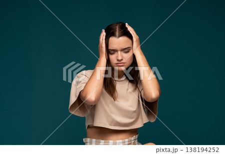 Young woman suffering from headache, experiencing migraine pain, stress, and frustration, holding head in distress 138194252