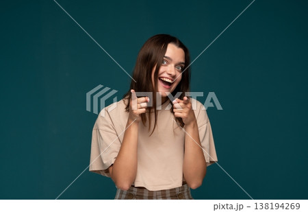 Young woman smiling, pointing fingers at camera, selecting or choosing you, expressing excitement and empowerment 138194269