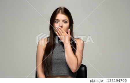 Woman gasping in surprise, covering mouth with hand, reacting with disbelief and wide-eyed shock Woman gasping in surprise, covering mouth with hand, reacting with disbelief and wide-eyed shock 138194706