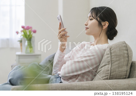 スマートフォンを持った若い女性の横顔 スマートフォンを持った若い女性の横顔 138195124