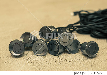 Grey parking sensors with wires on the concrete surface Grey parking sensors with wires on the concrete surface 138195778
