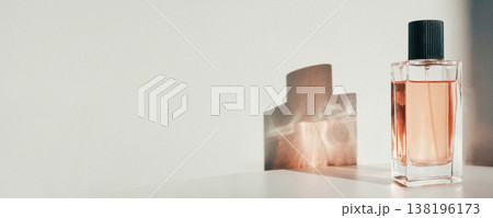 Glass perfume bottle standing on white surface with shadow, banner format 138196173