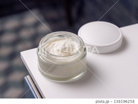 Opened cosmetic cream jar mockup with a blank lid against blue tiled floor top view 138196258