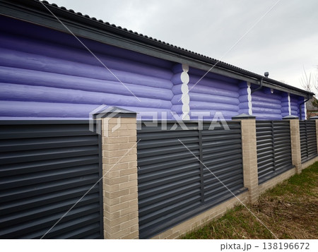 Colorful wooden wall with gray fence in a rural setting during a cloudy day Colorful wooden wall with gray fence in a rural setting during a cloudy day 138196672