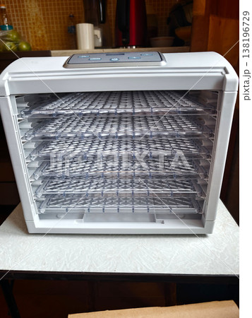 Drying food with a kitchen food dehydrator during daytime at home 138196729