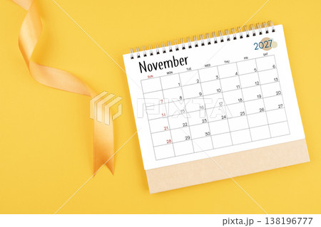 November 2027 desk calendar with yellow ribbon on yellow color background. 138196777