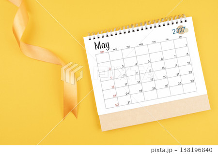 May 2027 desk calendar with yellow ribbon on yellow color background. May 2027 desk calendar with yellow ribbon on yellow color background. 138196840