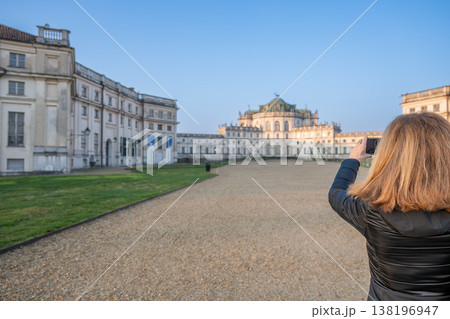 Stupinigi, turin, italy. March 23,2026. Woman holding a smartphone, capturing a beautiful view of the historic palazzina di caccia di stupinigi on a clear day Stupinigi, turin, italy. March 23,2026. Woman holding a smartphone, capturing a beautiful view of the historic palazzina di caccia di stupinigi on a clear day 138196947